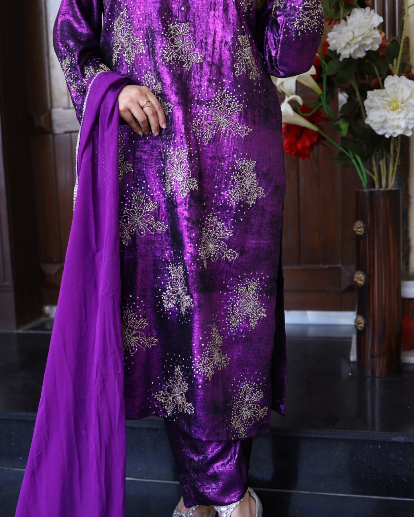 Purple traditional outfit with floral patterns on a dark background