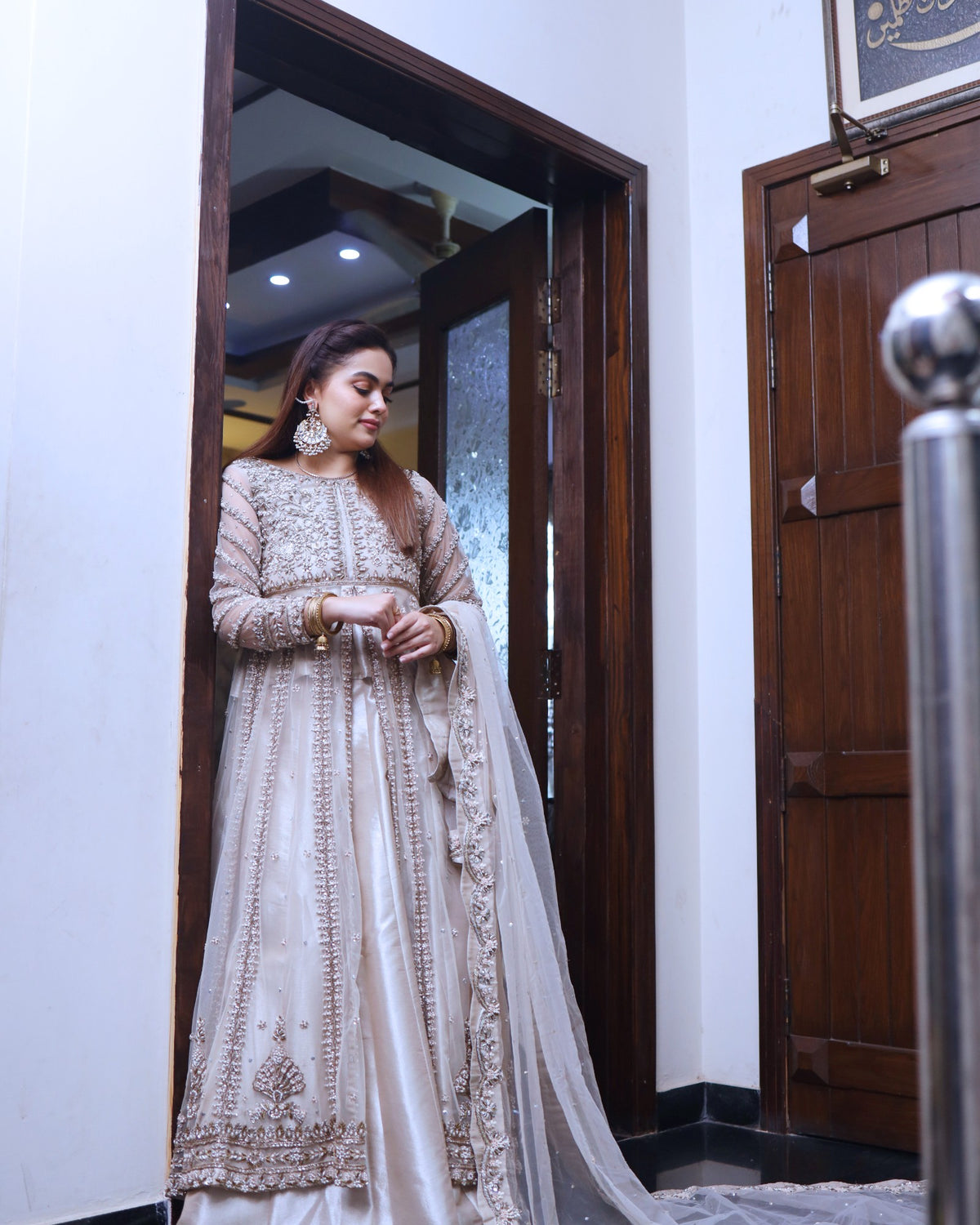 Woman in a traditional outfit standing in a doorway.