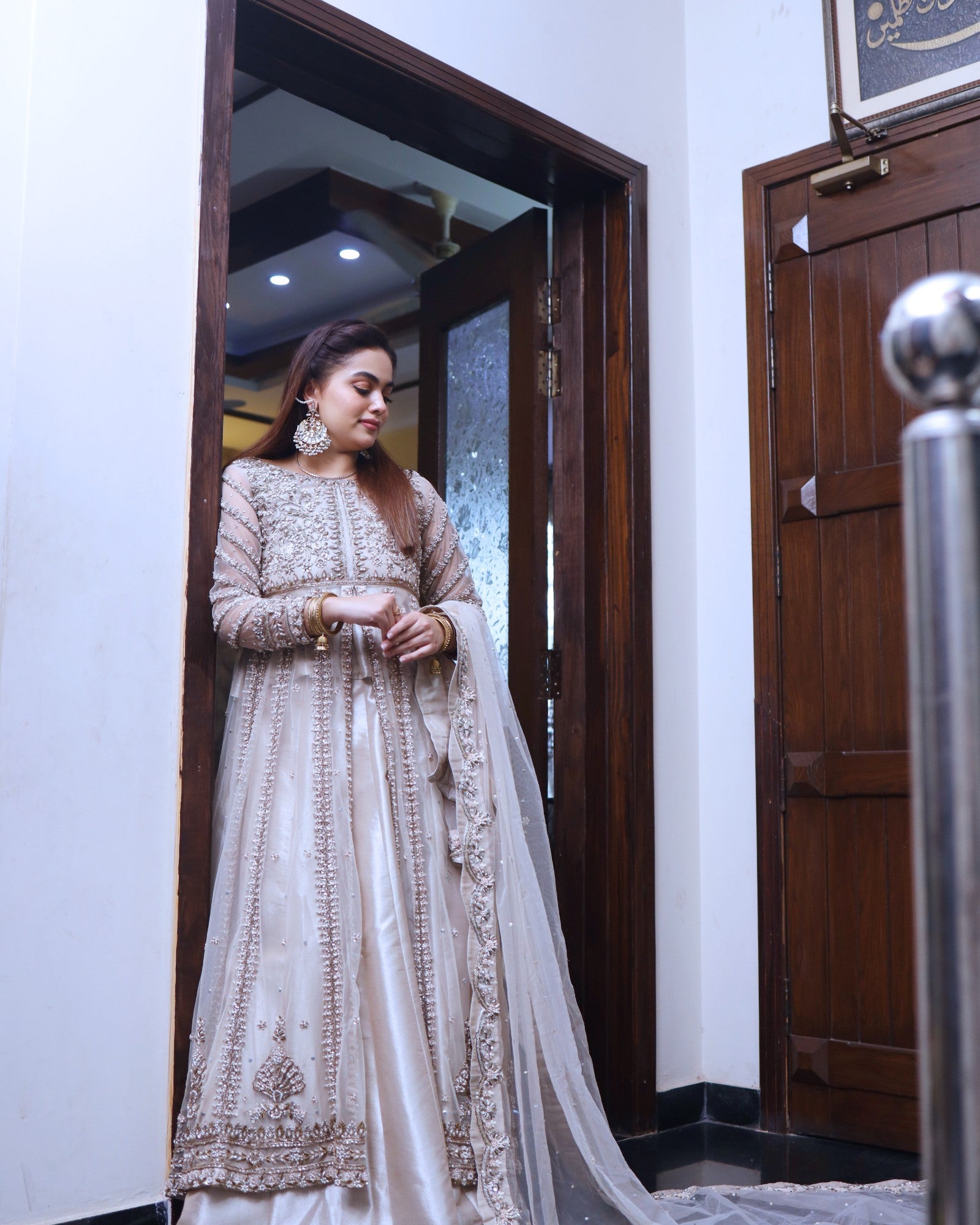 Woman in a traditional outfit standing in a doorway.