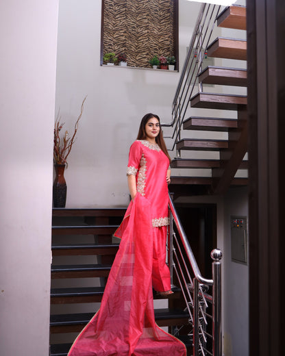 Woman in a pink traditional outfit standing on a staircase