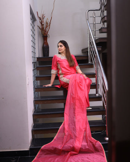 Woman in a pink saree sitting on a staircase
