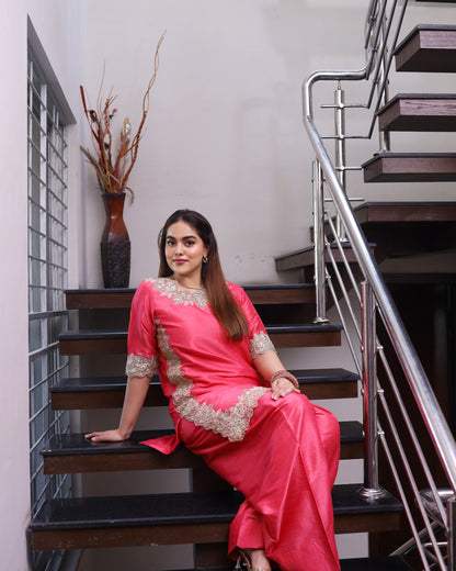 Woman in a pink saree sitting on a staircase