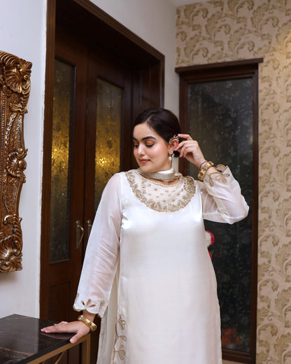Woman adjusting earrings in a room with decorative elements