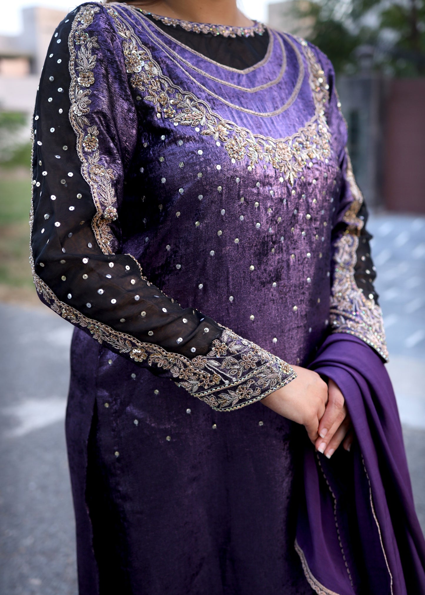 Purple traditional outfit with intricate embroidery on a blurred background