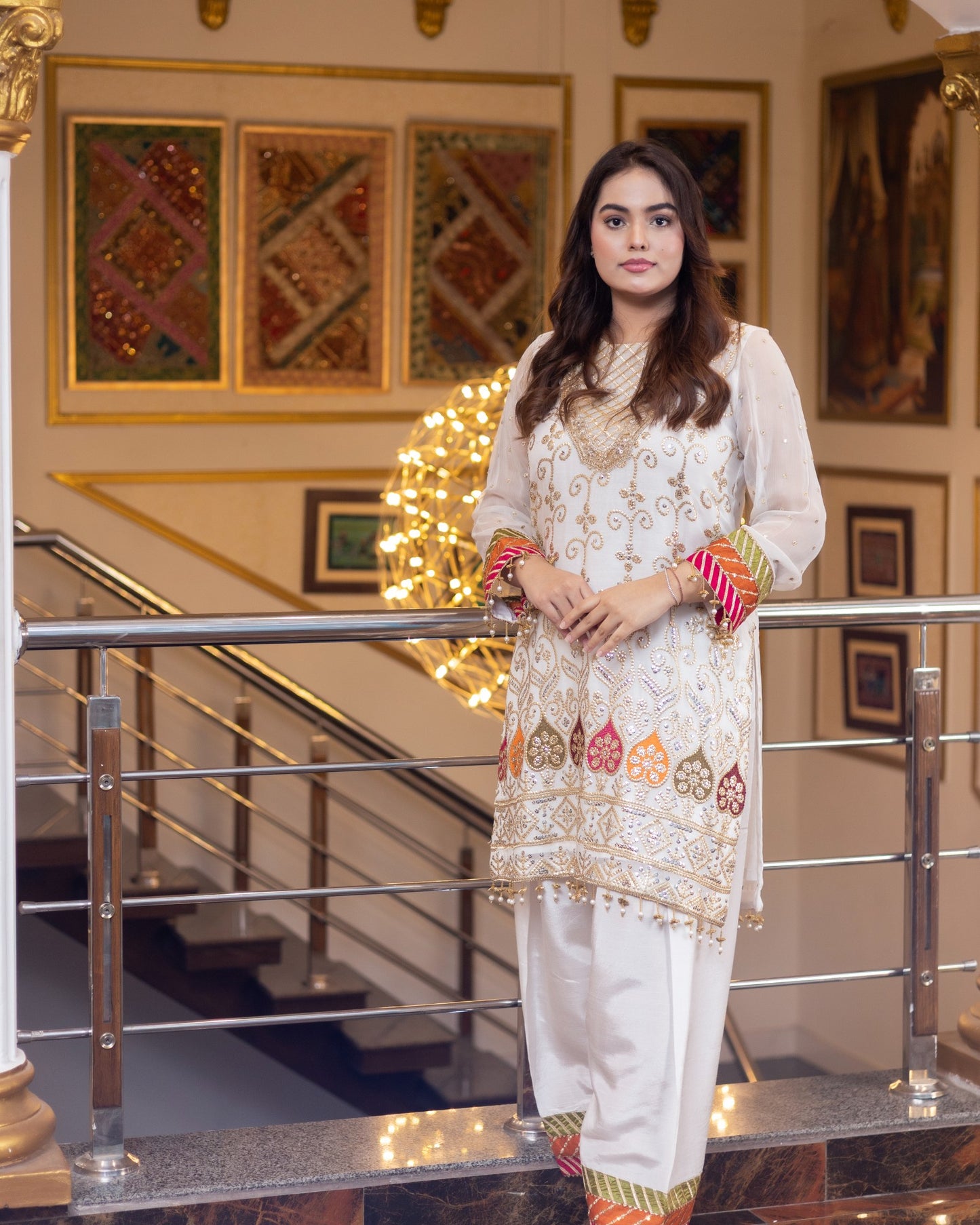 Woman in traditional outfit standing in a decorated interior setting