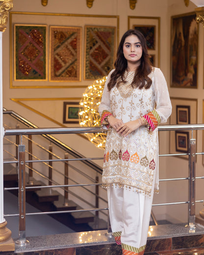 Woman in traditional outfit standing in a decorated interior setting