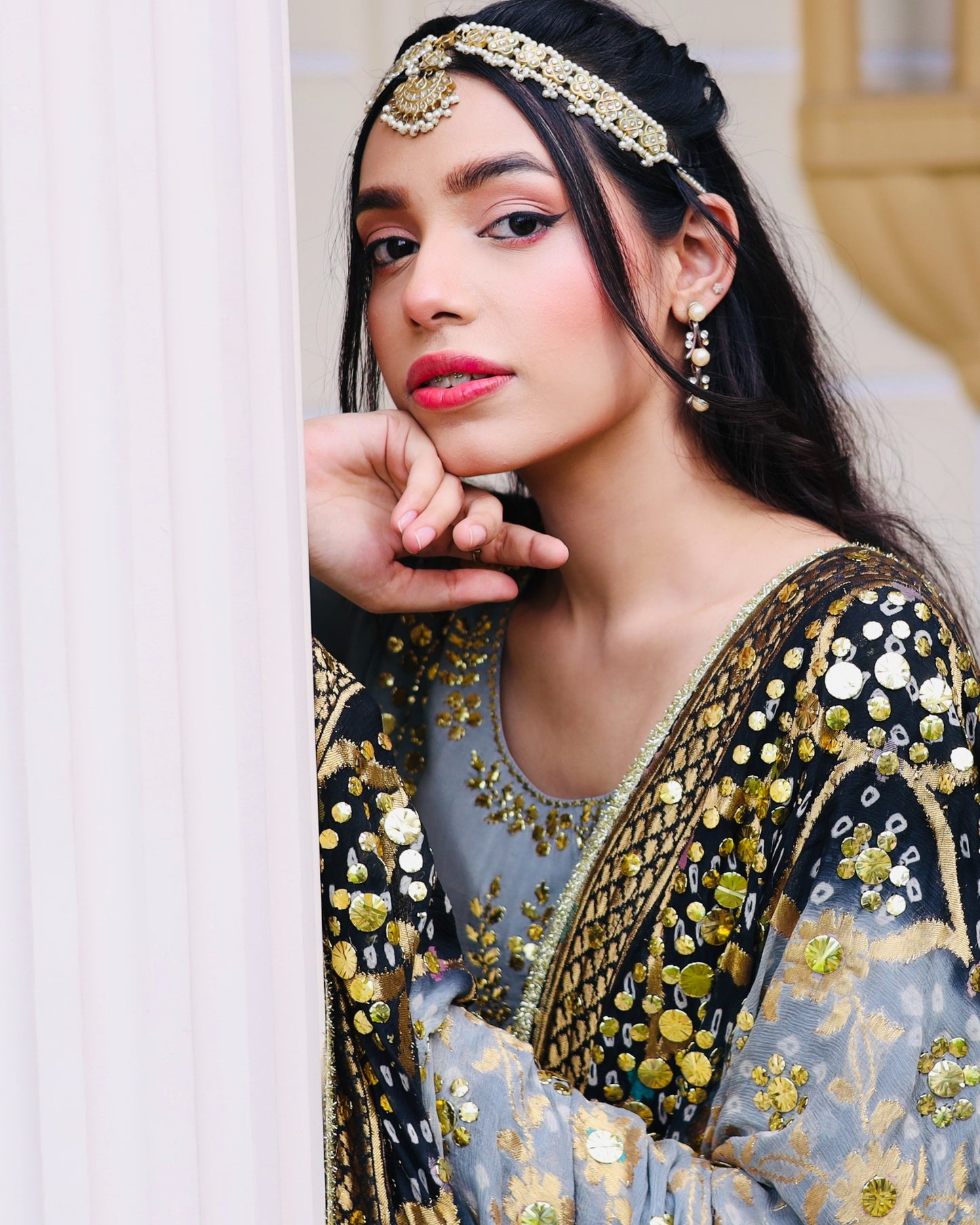 Woman wearing traditional embroidered attire with gold and black details.