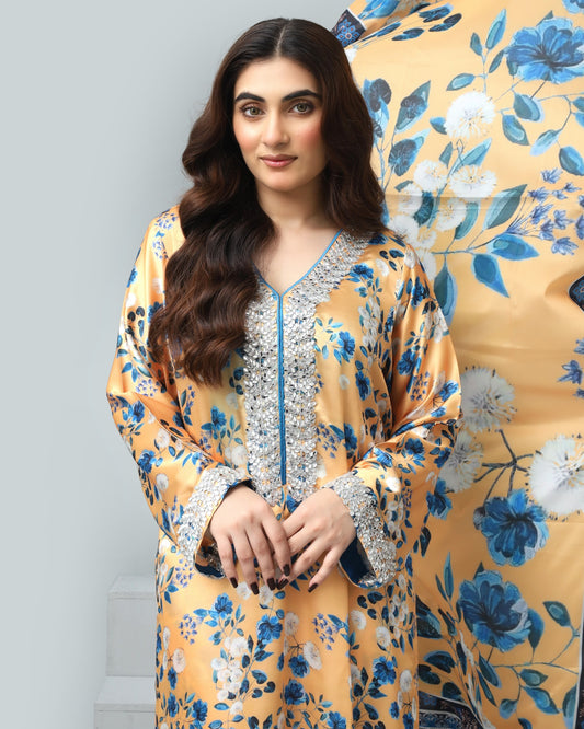 Woman wearing a yellow floral dress with a blue floral pattern in the background